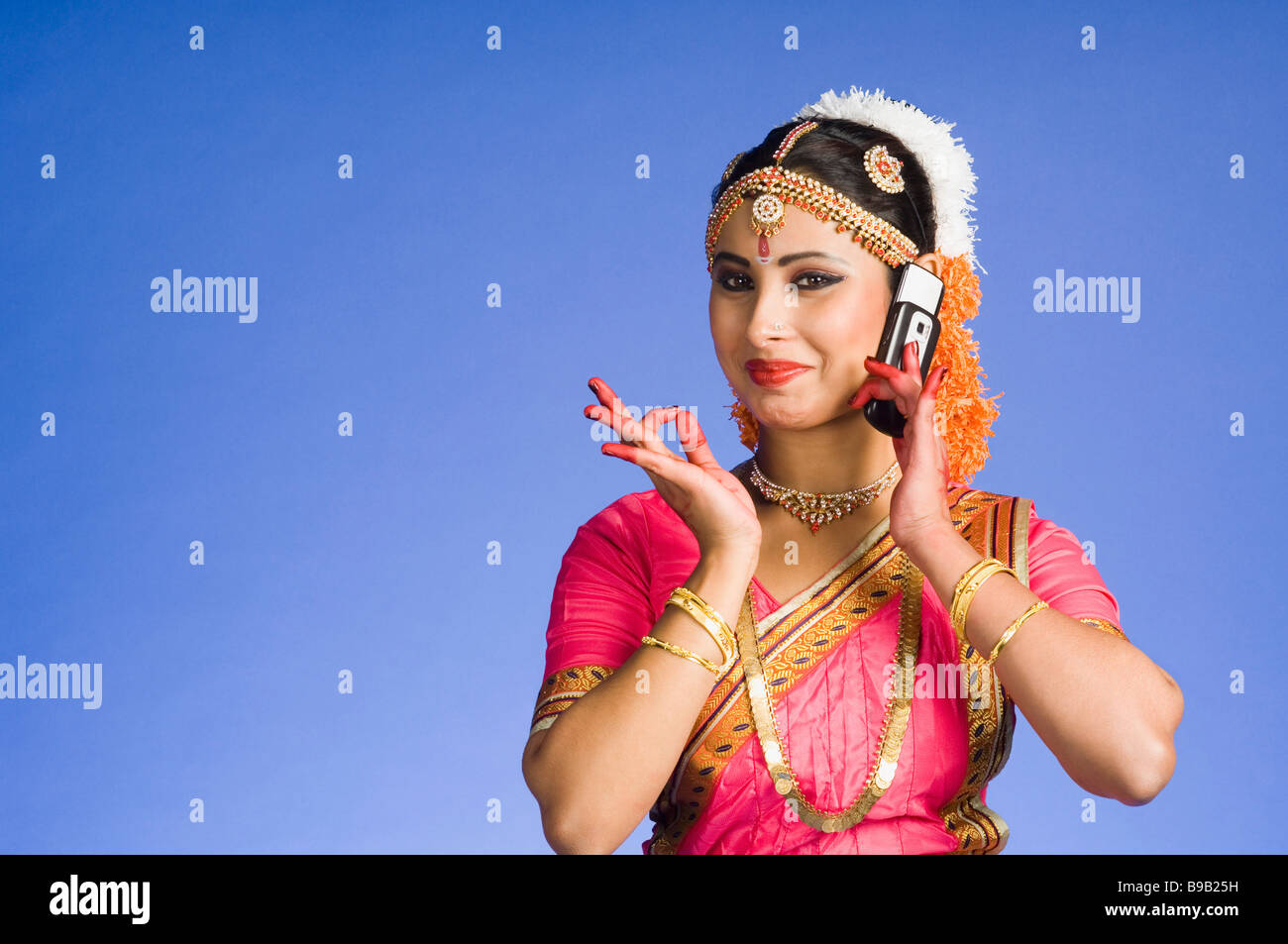 Female Dancer talking on a mobile phone in and performing Bharatnatyam ...