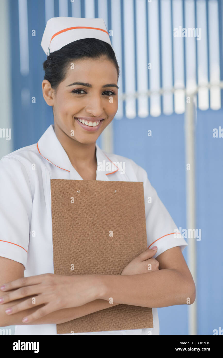 Female nurse holding a clipboard and smiling Stock Photo - Alamy