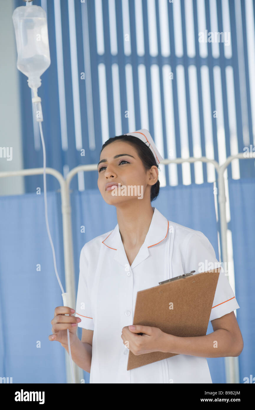 Female nurse adjusting a saline drip Stock Photo