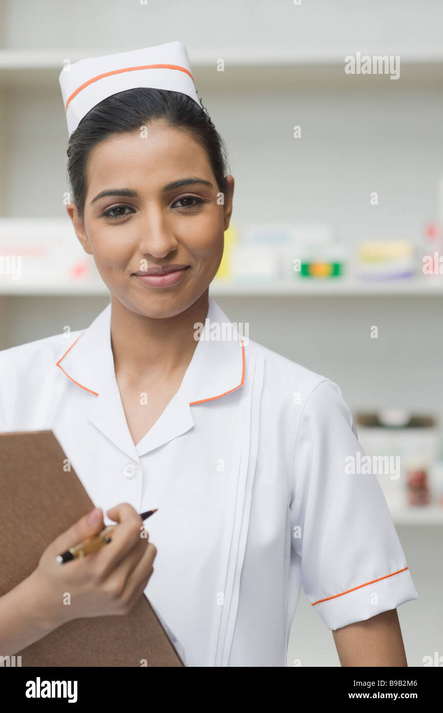 Female nurse holding a clipboard and smiling Stock Photo - Alamy