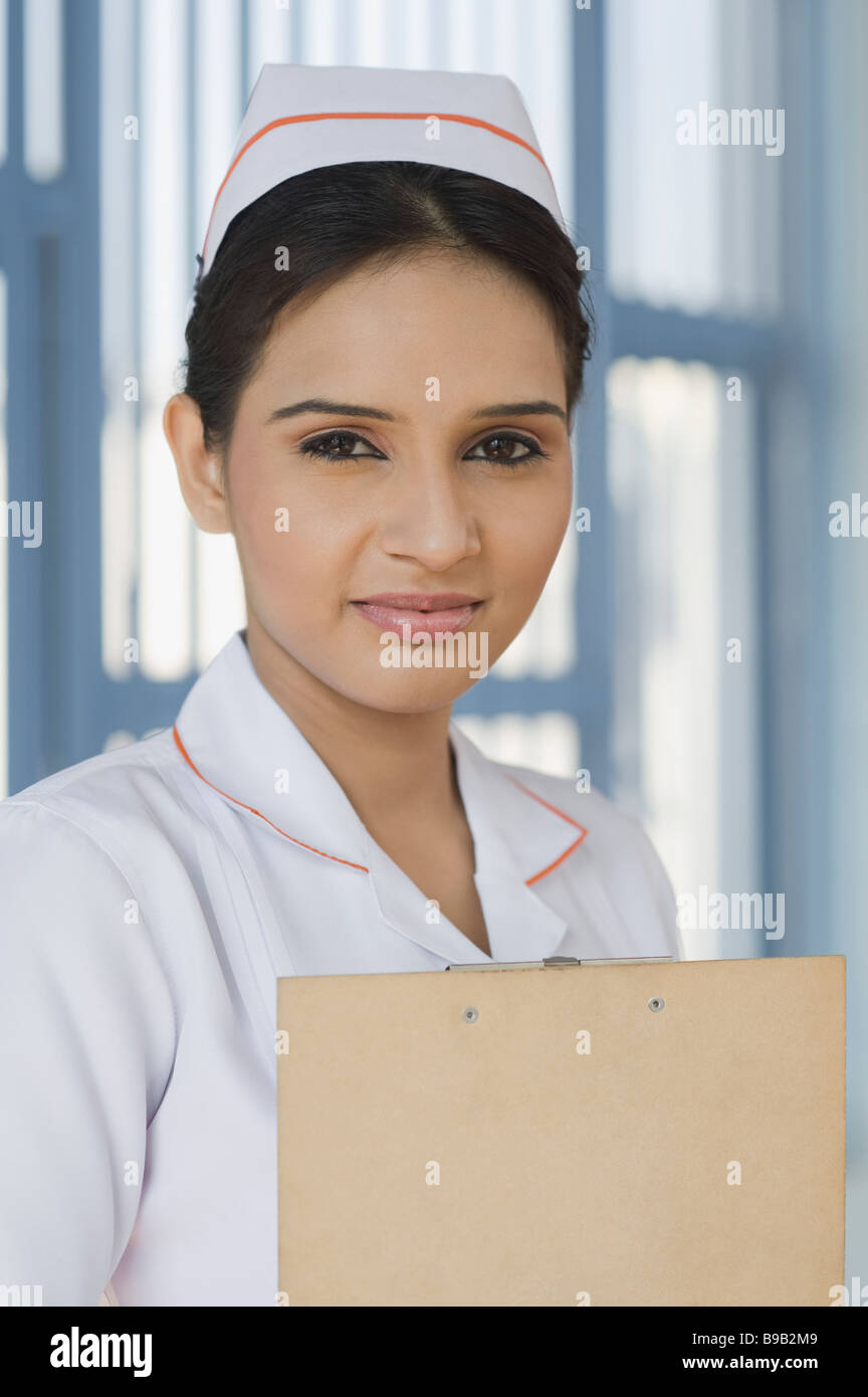 Female nurse holding a clipboard and smiling Stock Photo - Alamy