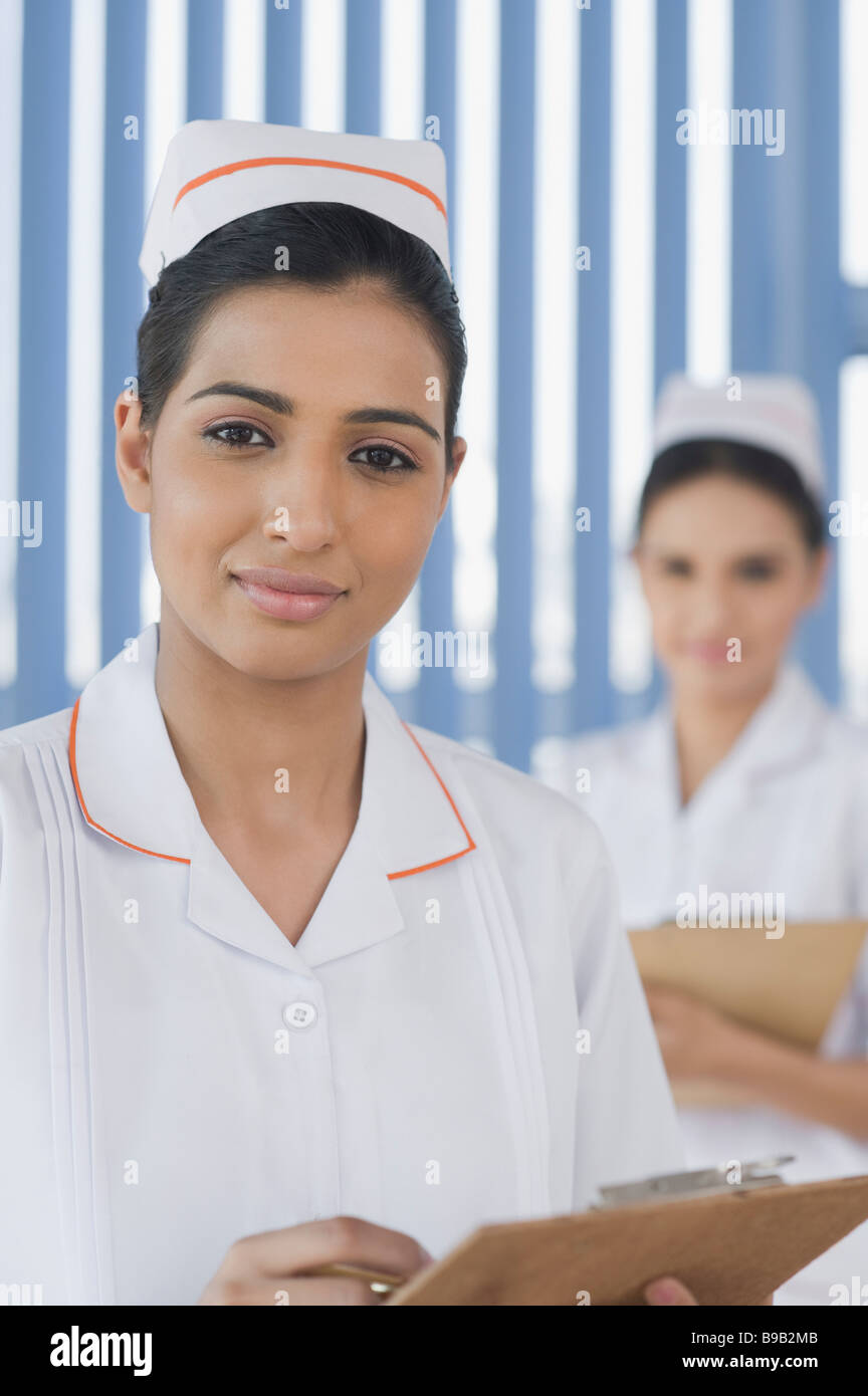 Two female nurses holding clipboards and smiling Stock Photo