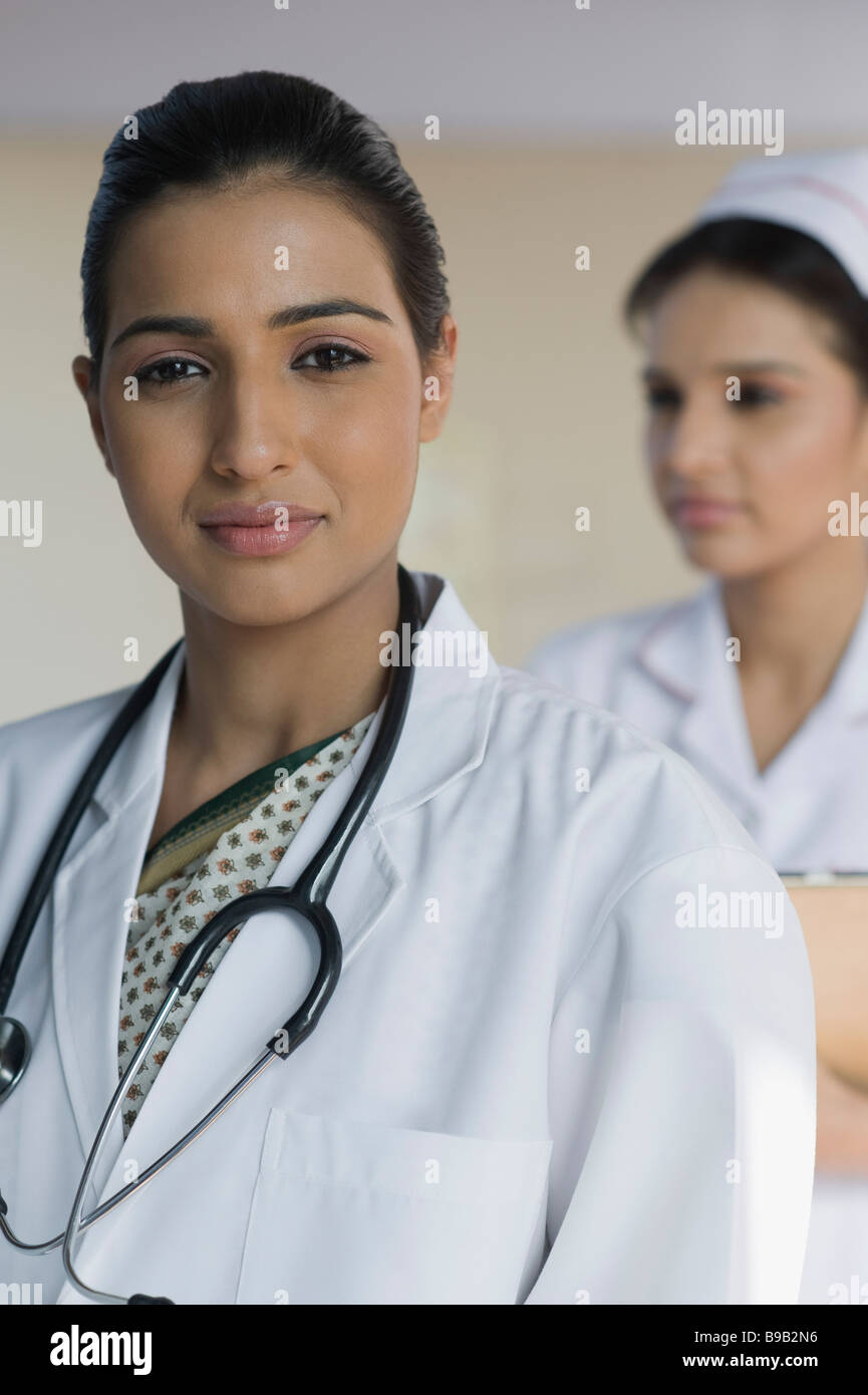 Portrait of a female doctor with a female nurse in the background Stock Photo