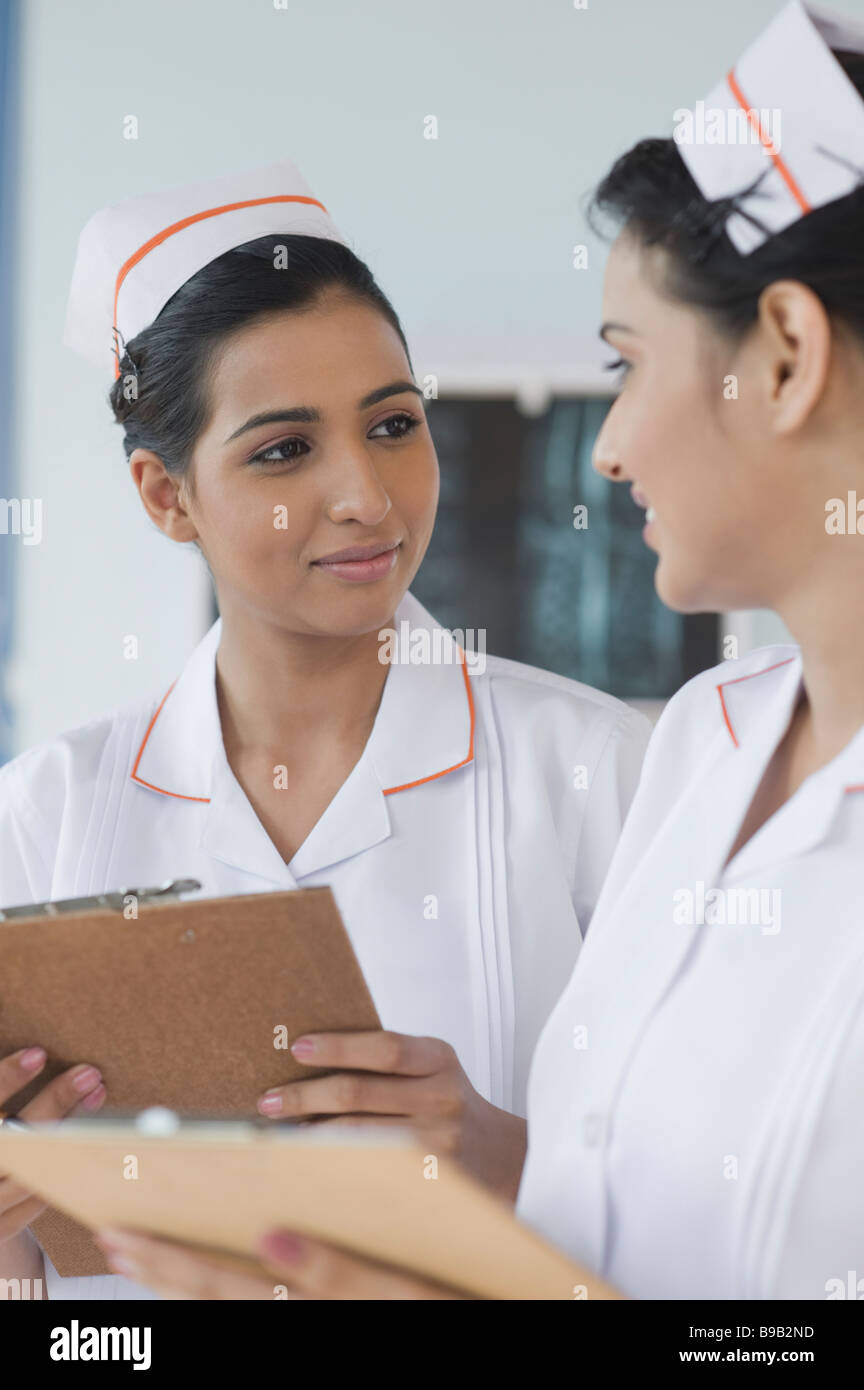 Two female nurses holding clipboards and smiling Stock Photo Alamy
