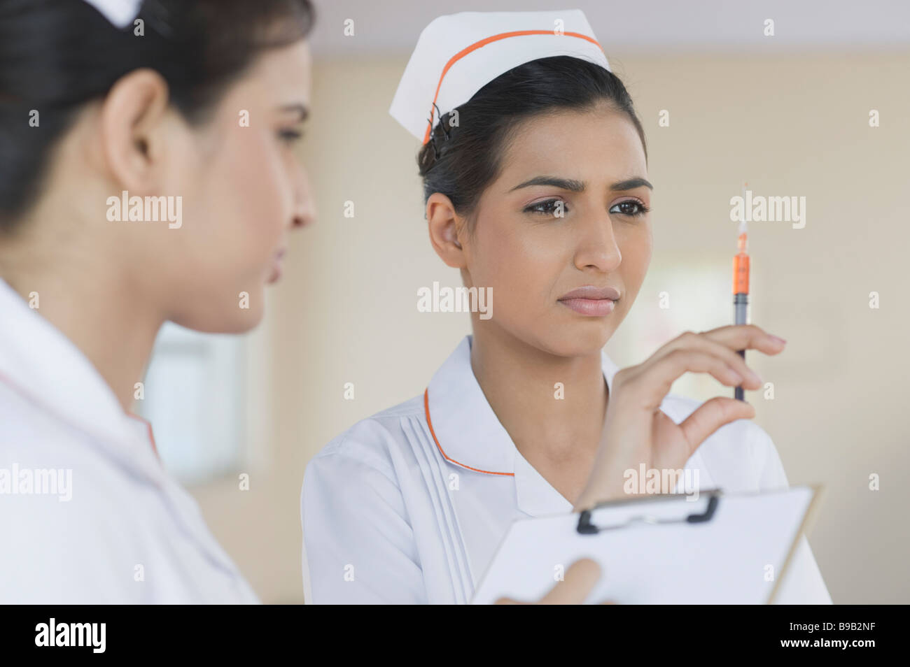 Female nurses holding clipboard and syringe Stock Photo - Alamy