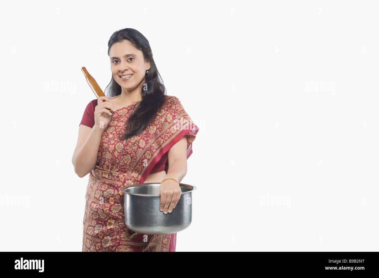 Woman holding a saucepan and a rolling pin Stock Photo