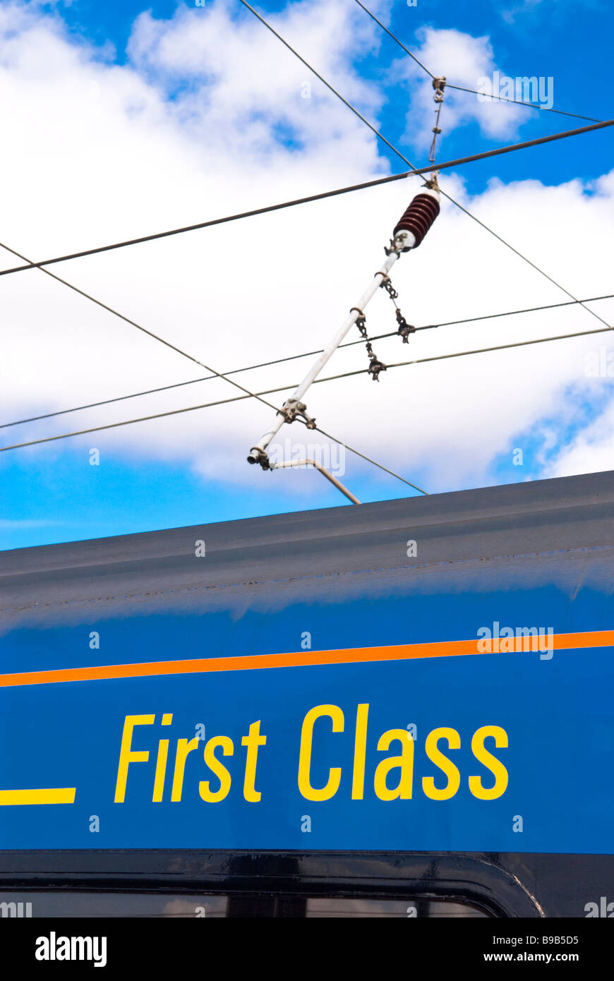 A first class train carriage with electric wires overhead Stock Photo