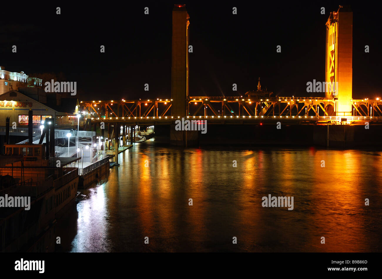 View of K Street Bridge and Sacramento River along Old Sacramento riverfront at night as seen from the Delta King riverboat Stock Photo