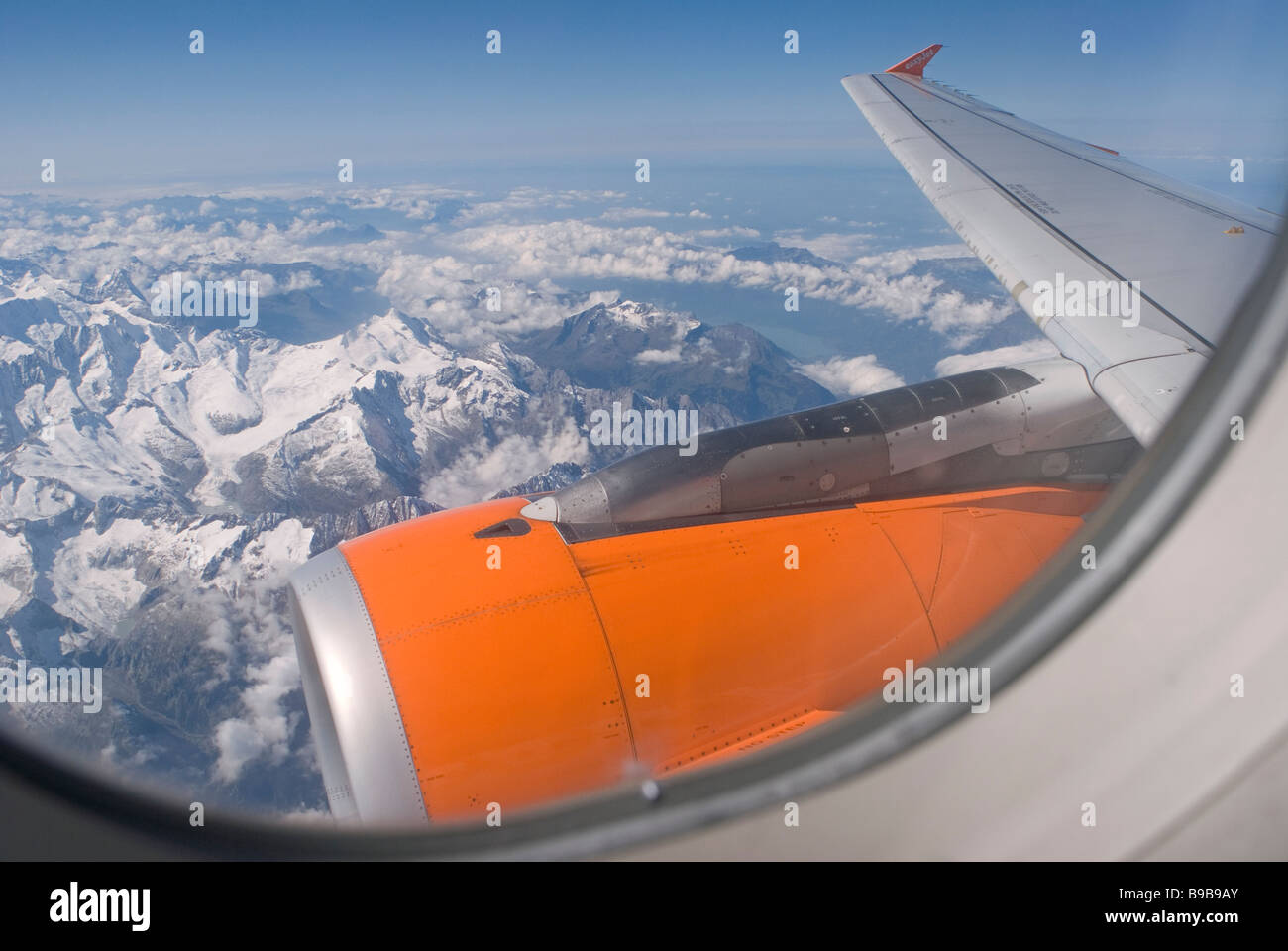 jet engine and a view from the window of a plane flying over Alps Stock Photo