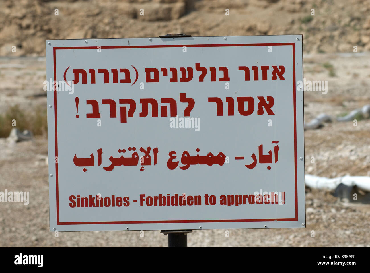 Warning sign for sinkholes at the Dead Sea coast in Israel Stock Photo
