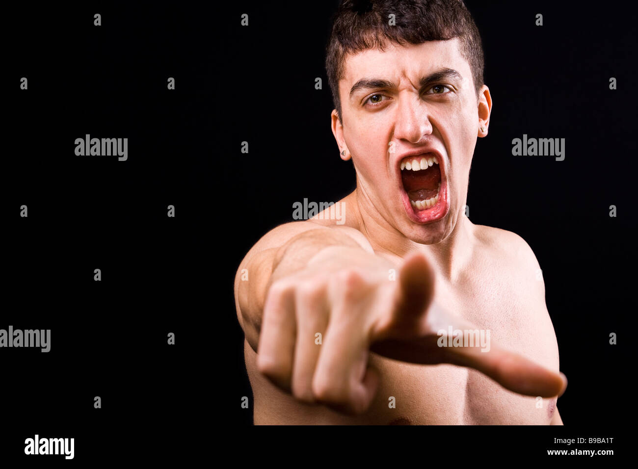 Loud scream of angry furious violent man pointing towards camera Stock Photo