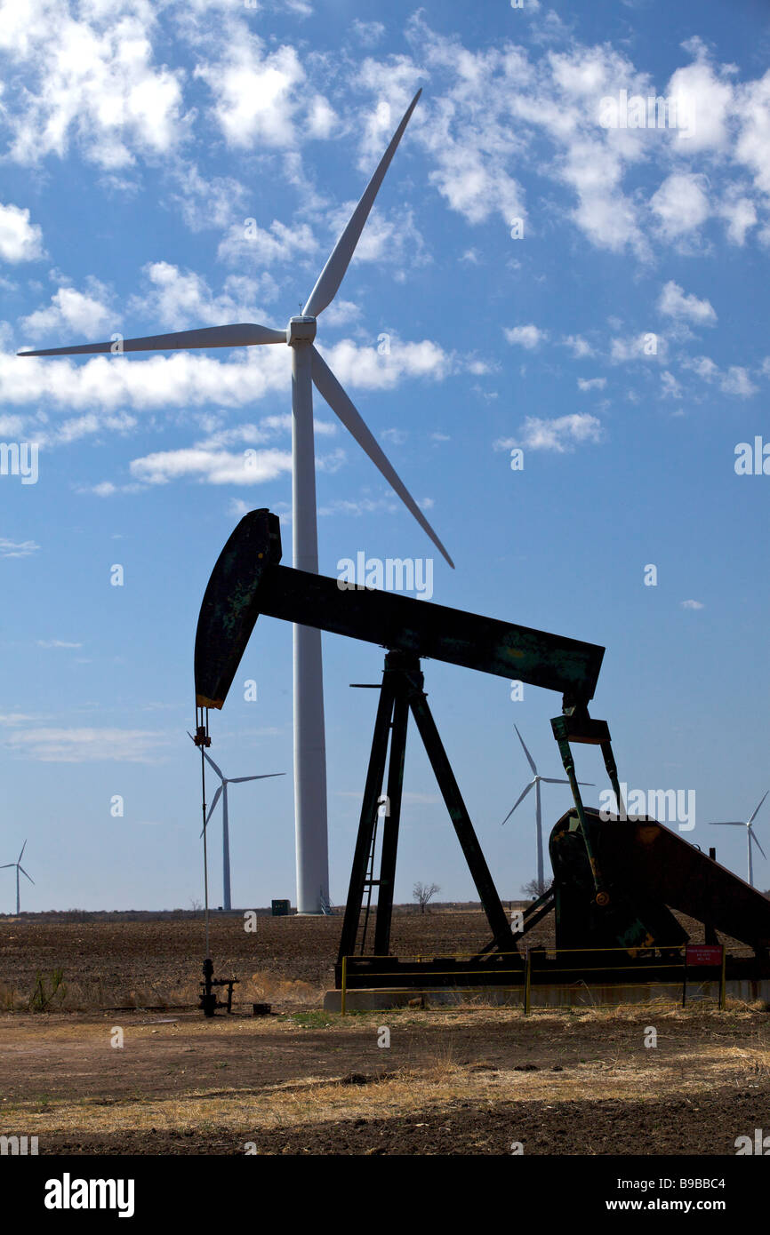 An oil well in the west Texas desert near wind turbines generating electricity at Horse Hollow Wind Farm Nolan Texas Stock Photo