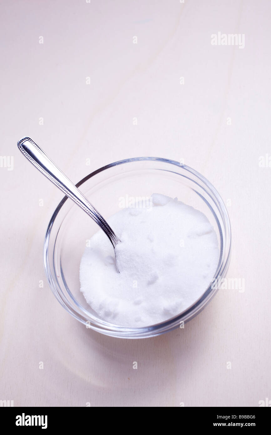 Glass bowl filled with sugar and spoon Stock Photo