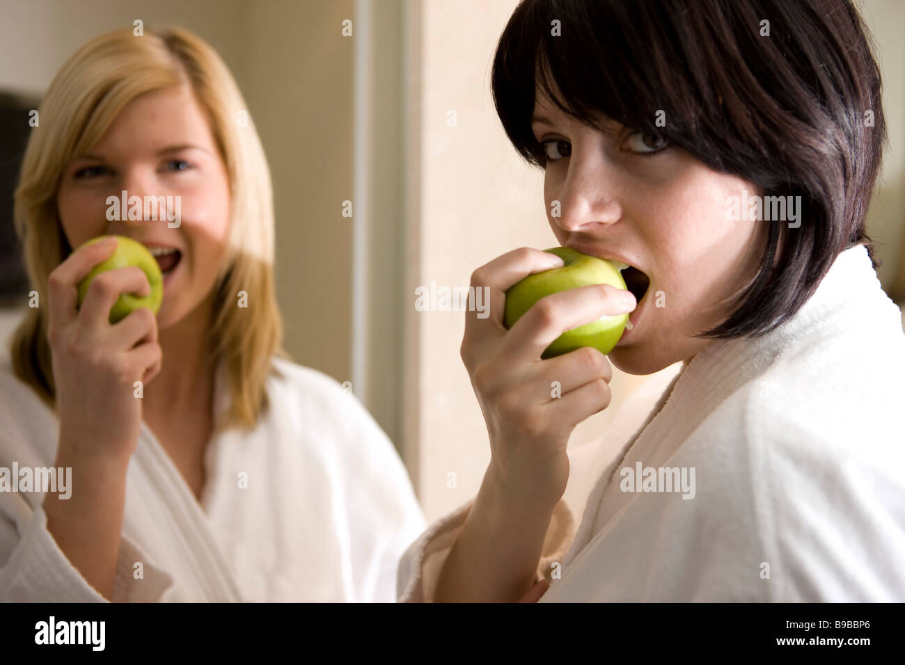 zwei frauen essen/ beissen in einen apfel Stock Photo