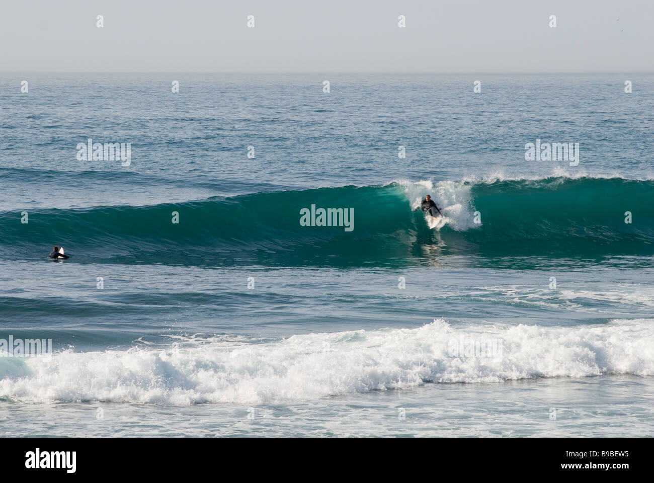 A surfer rides a wave at Cap Rihr on the central Moroccan coast. Stock Photo
