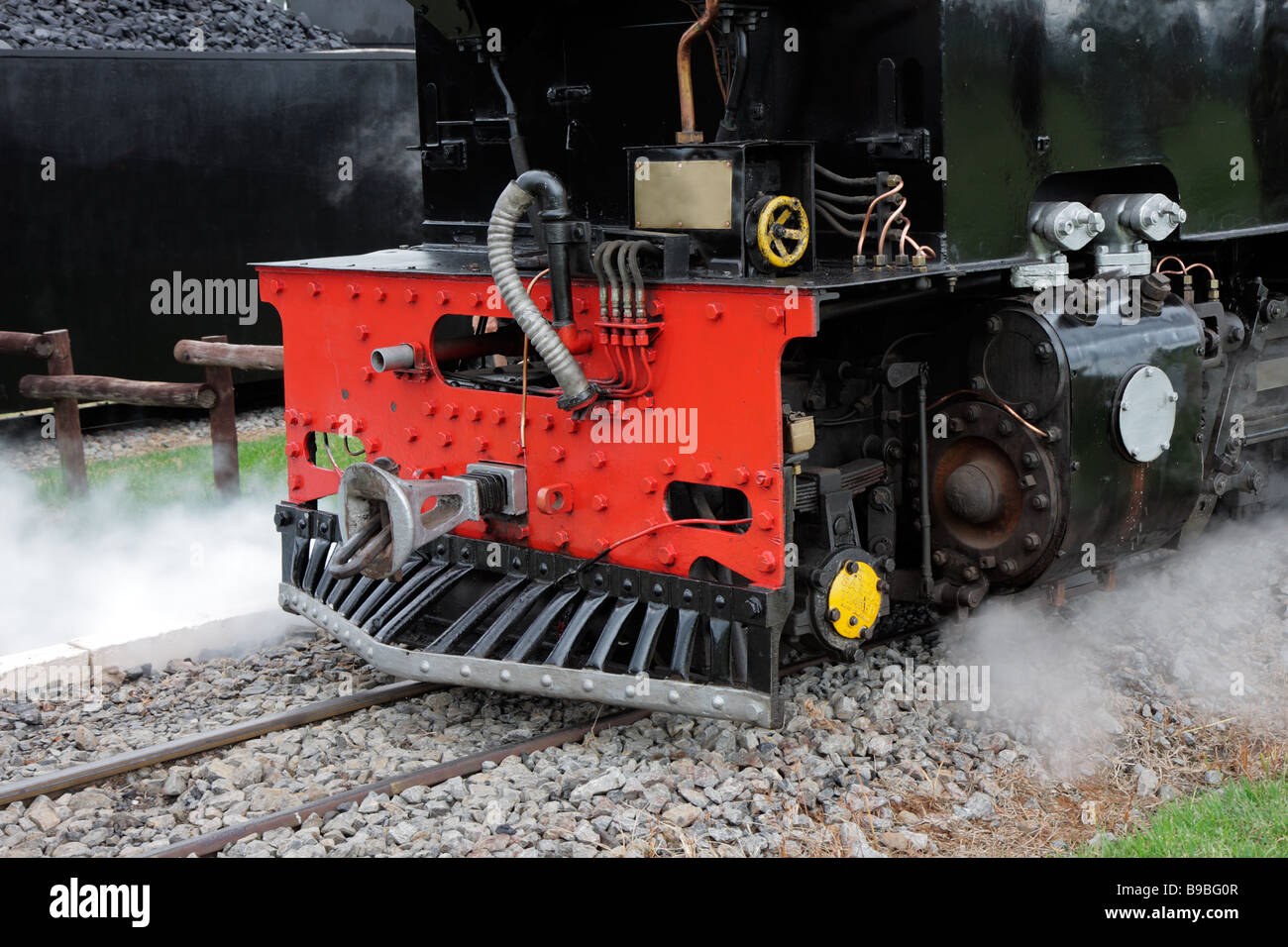 Close up of the front of a vintage steam locomotive with steam Stock Photo