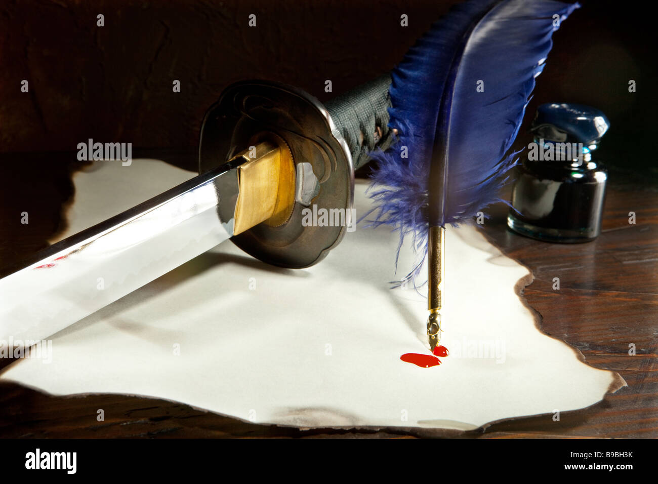 Japanese sword on a parchment letter quill and blood drops Stock Photo