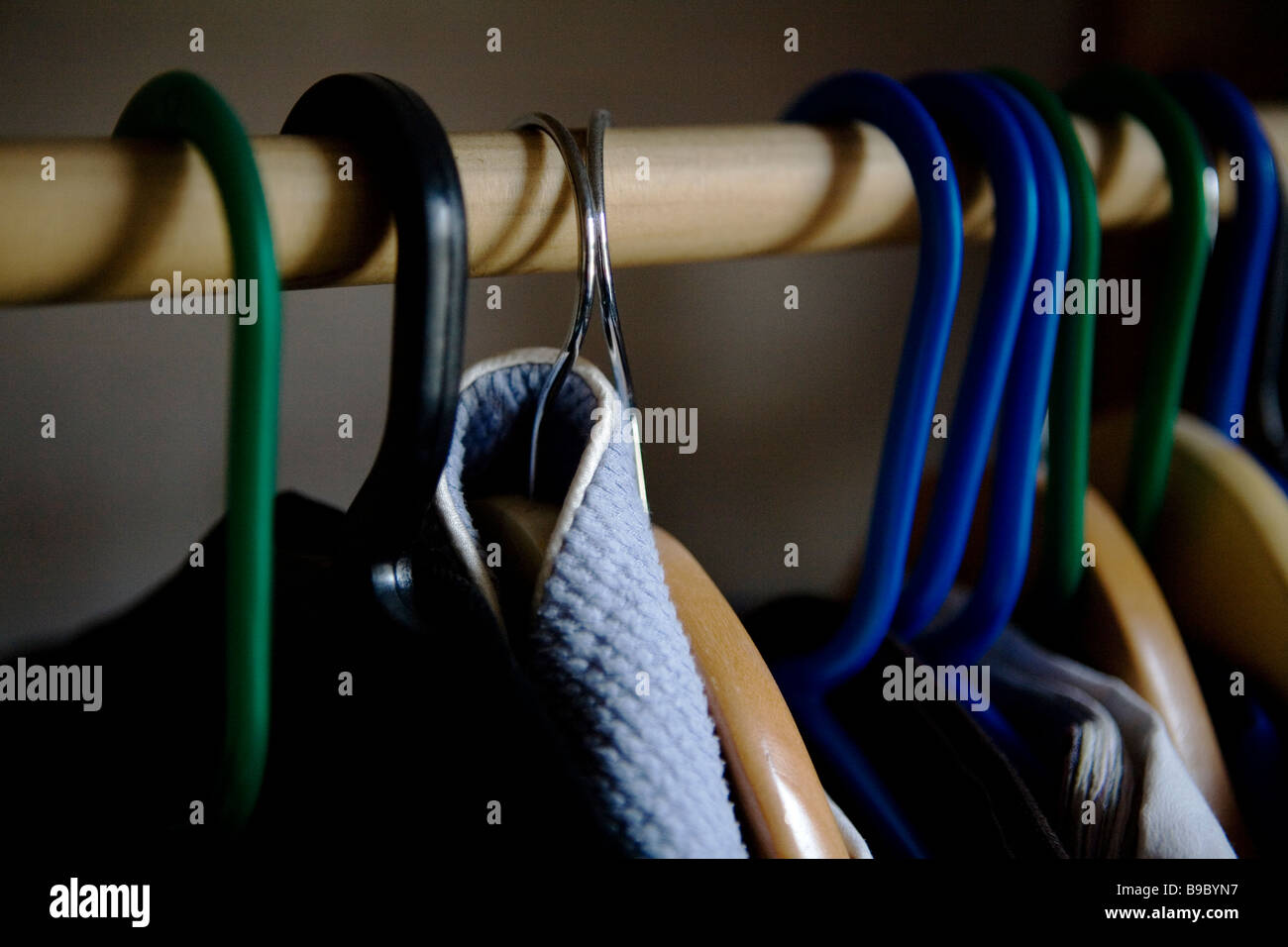 Clothes hanging in a cupboard. Stock Photo