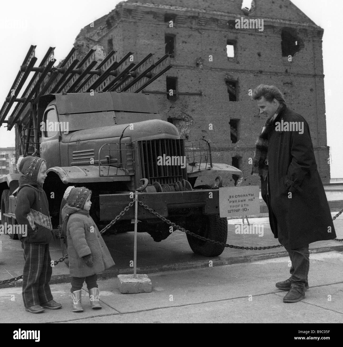 A man and his daughters look at a Katyusha missile launcher mounted ...