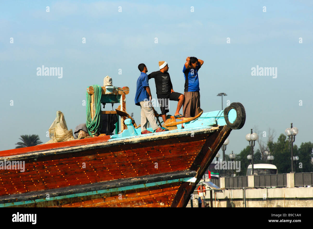 The crew of a traditional merchant ship watching the arrival in the Dhow port of Dubai, United Arab Emirates Stock Photo