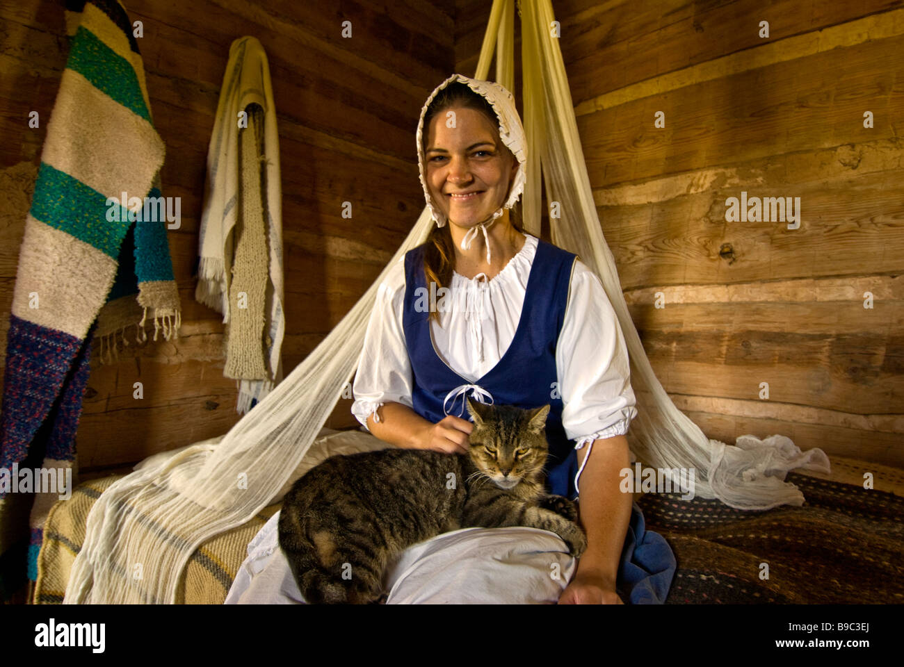American frontier woman settler in bedroom with cat 1830s Jones Stock Farm George Ranch Historical Park Houston texas tx Stock Photo