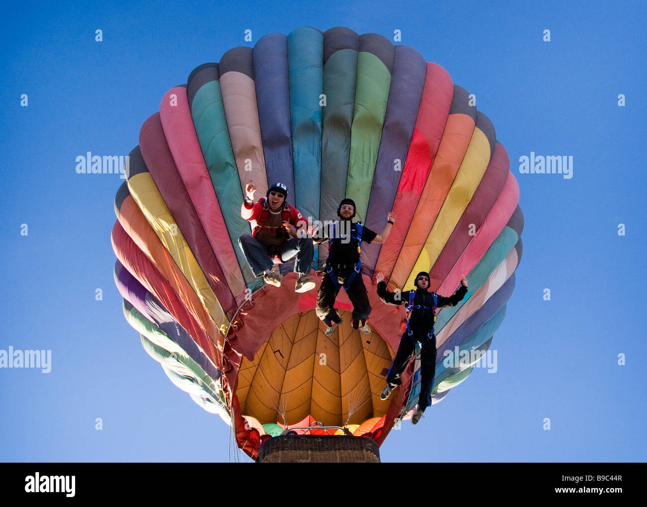 Three skydivers jumping from a hot air balloon at an altitude of 5,000