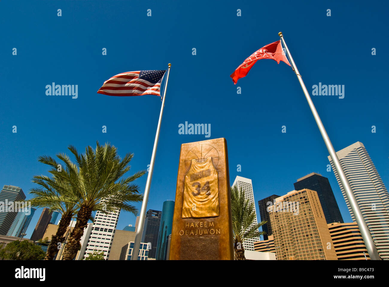 Hakeem Olajuwon Houston Texas astros NBA basketball player bronze monument two american flags  city landmark at Toyota Center Stock Photo