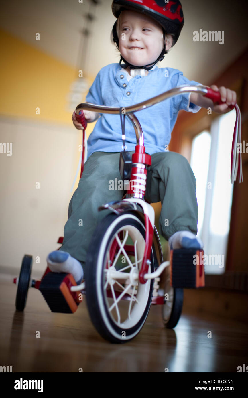Toddler riding a tricycle around the house Stock Photo Alamy