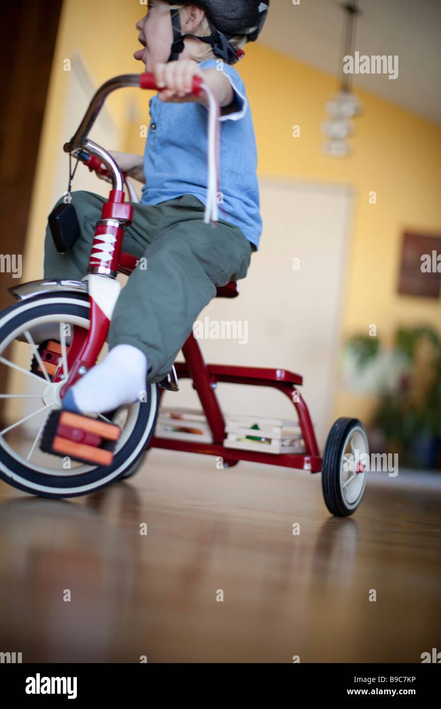 Toddler riding a tricycle around the house Stock Photo Alamy