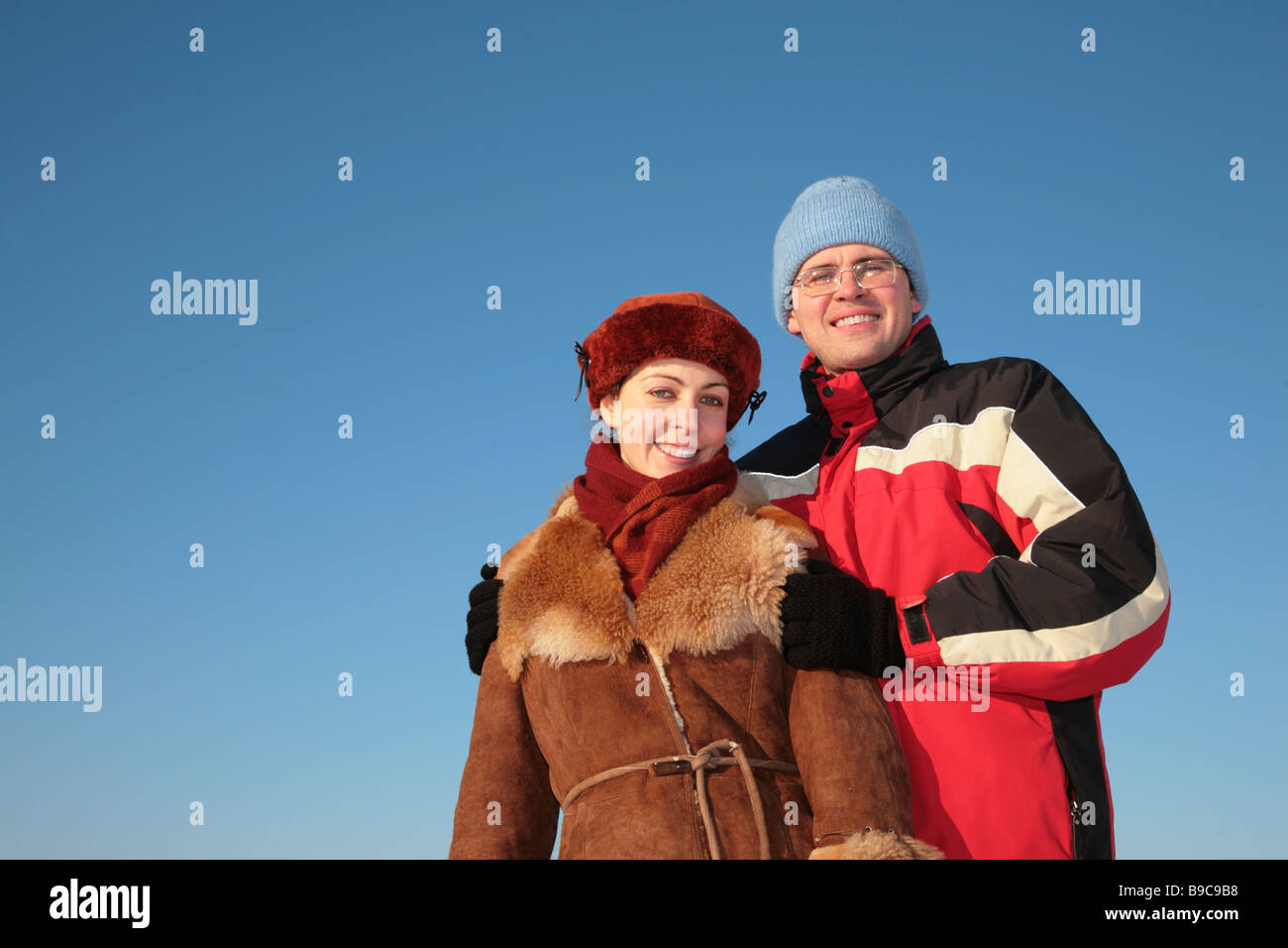 couple against blue sky background in winter 2 Stock Photo - Alamy