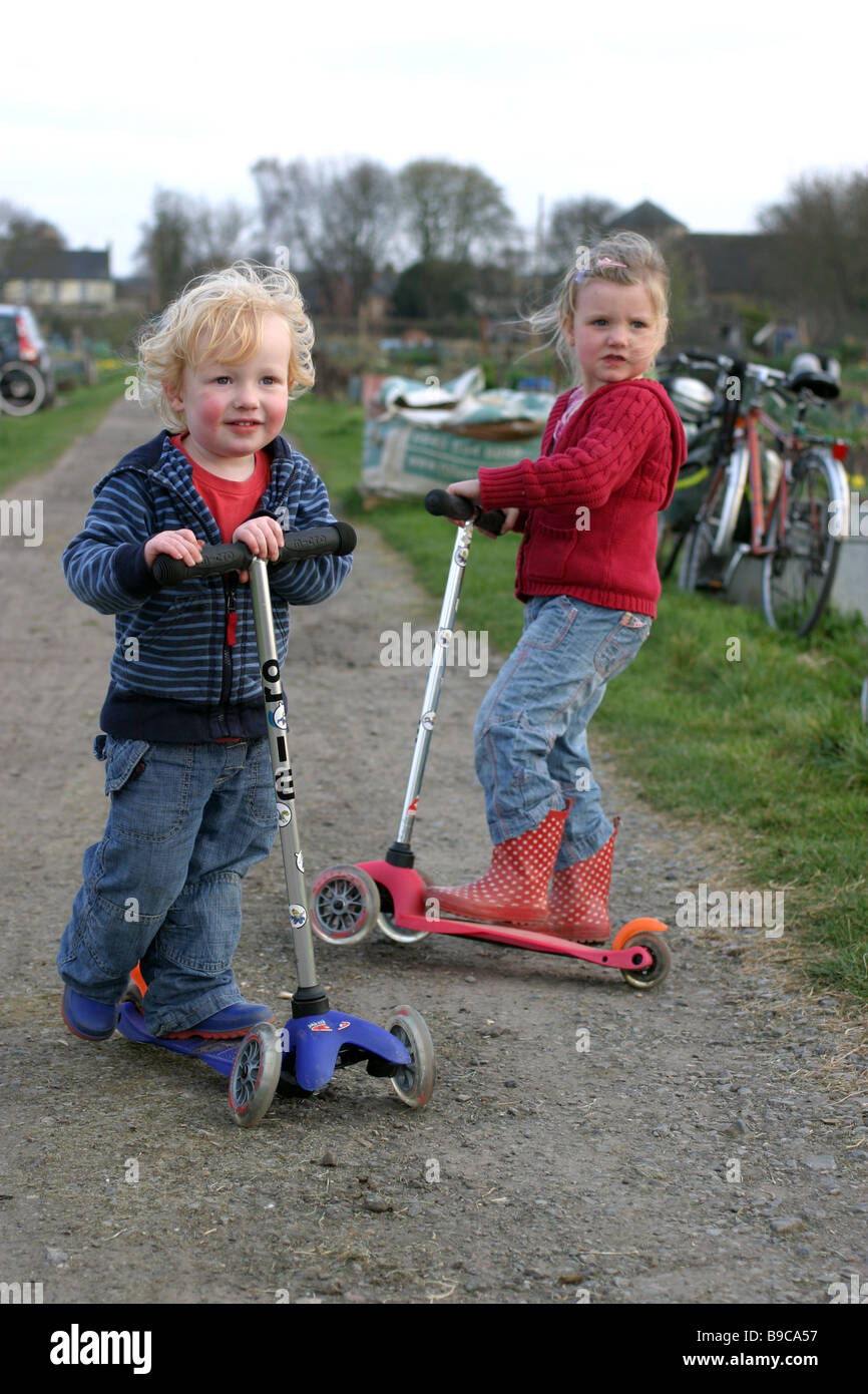 Children riding micro scooters Stock Photo Alamy