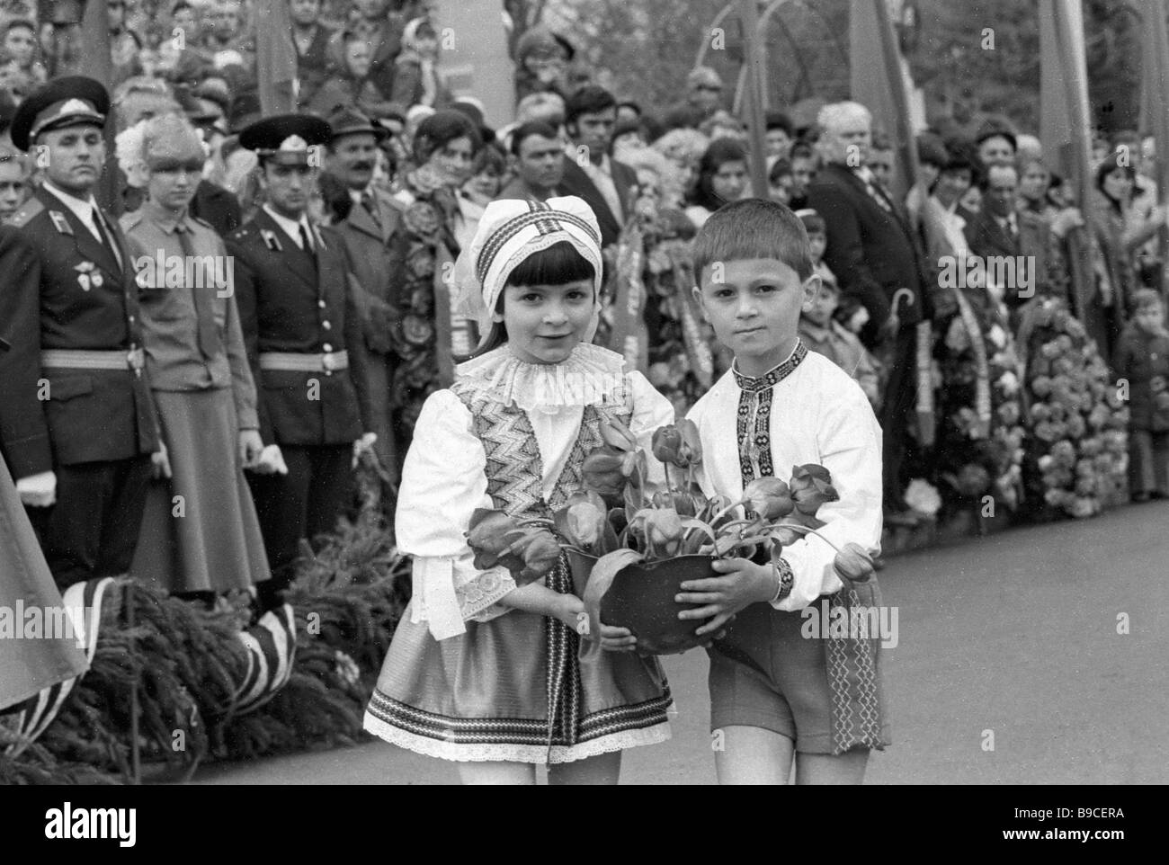 Children in folk Ukrainian costumes laying flowers to the monument of ...