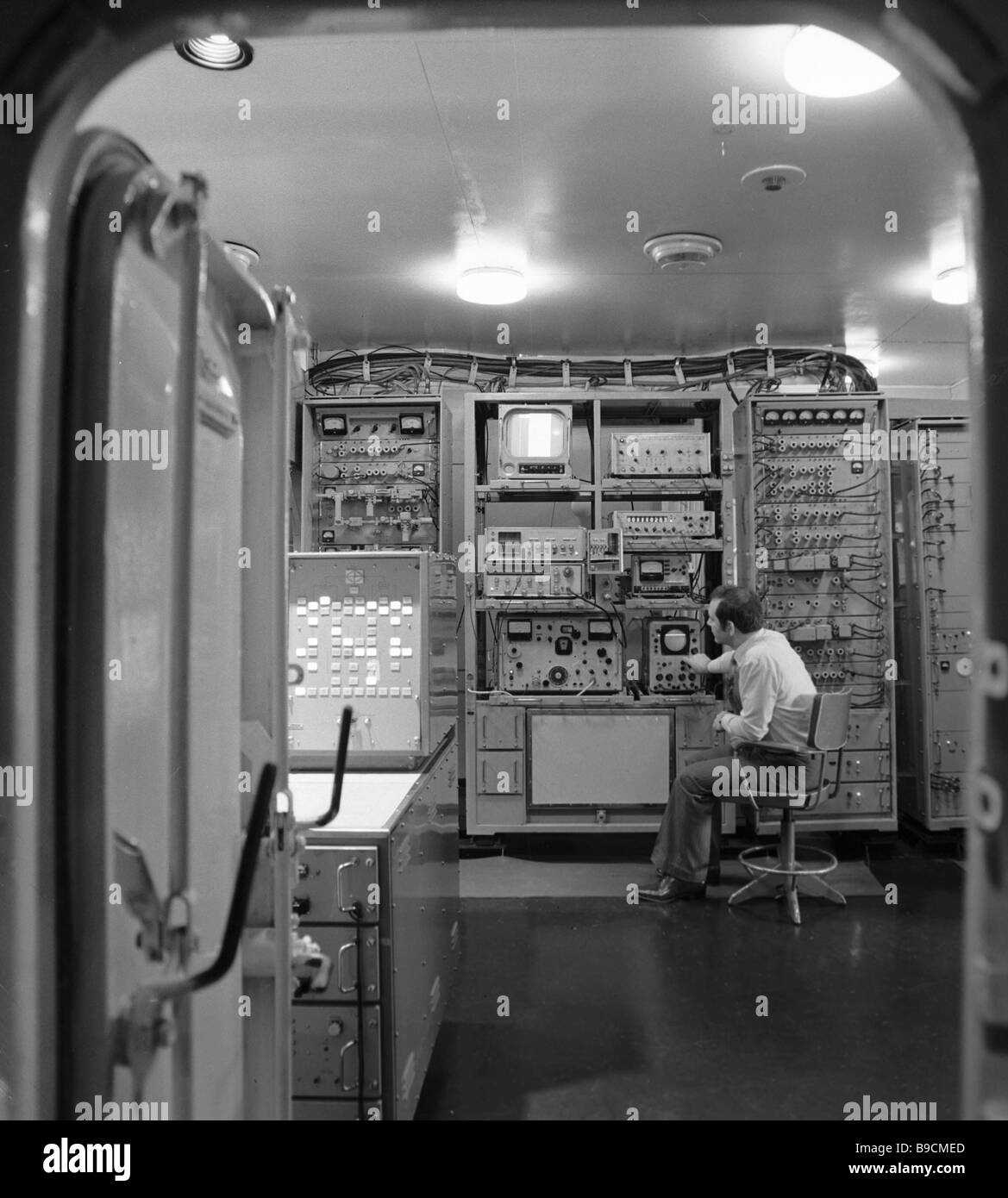 An engineer monitors equipment readings in the satellite communication