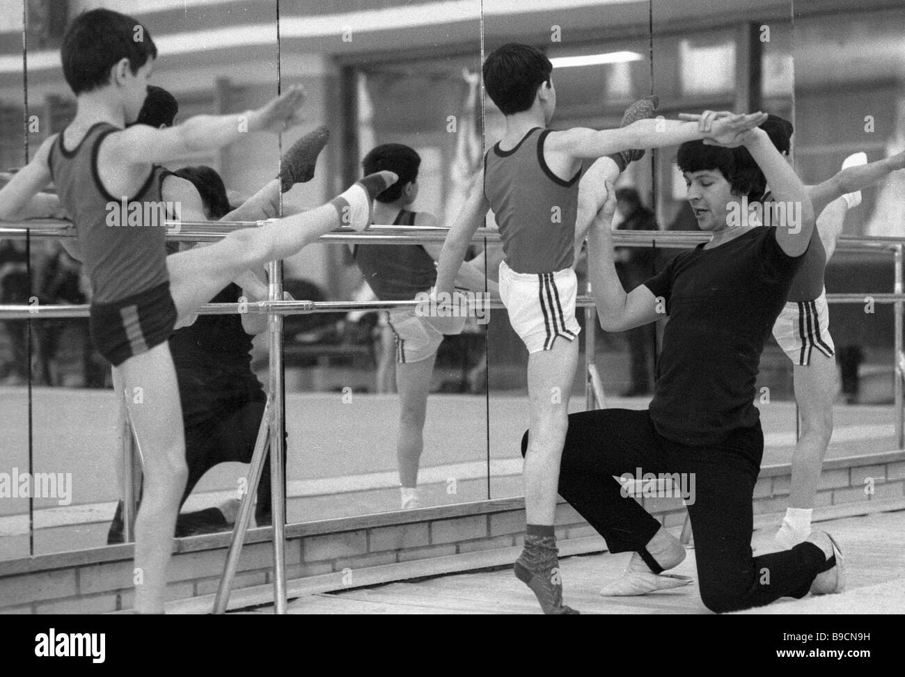 Coach showing bar exercises gymnastics school Moscow City Council ...