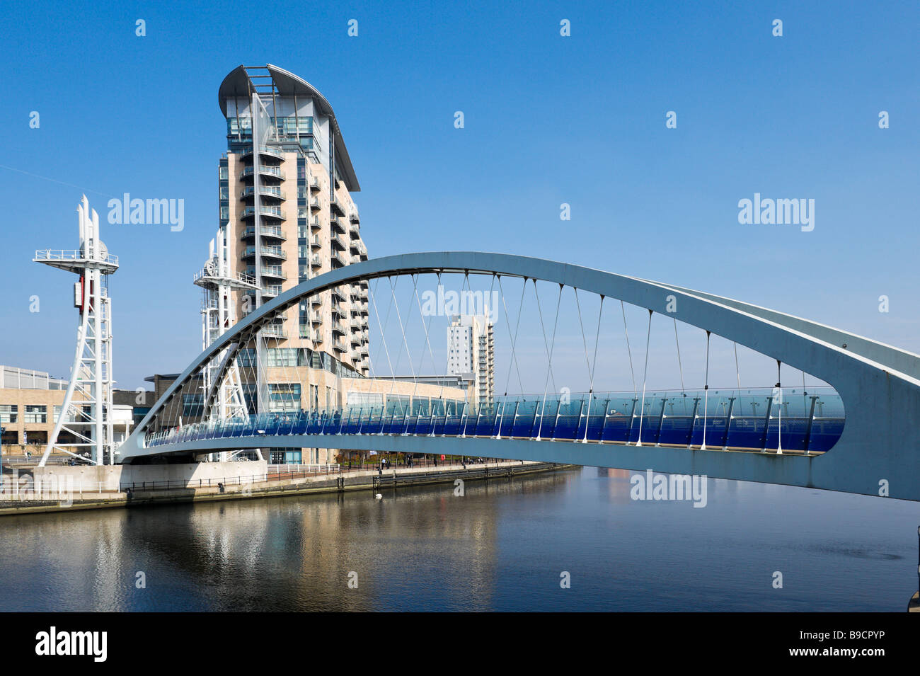 Modern flats behind the Millennium lifting footbridge over the Manchester Ship Canal, Salford Quays, Greater Manchester, England Stock Photo