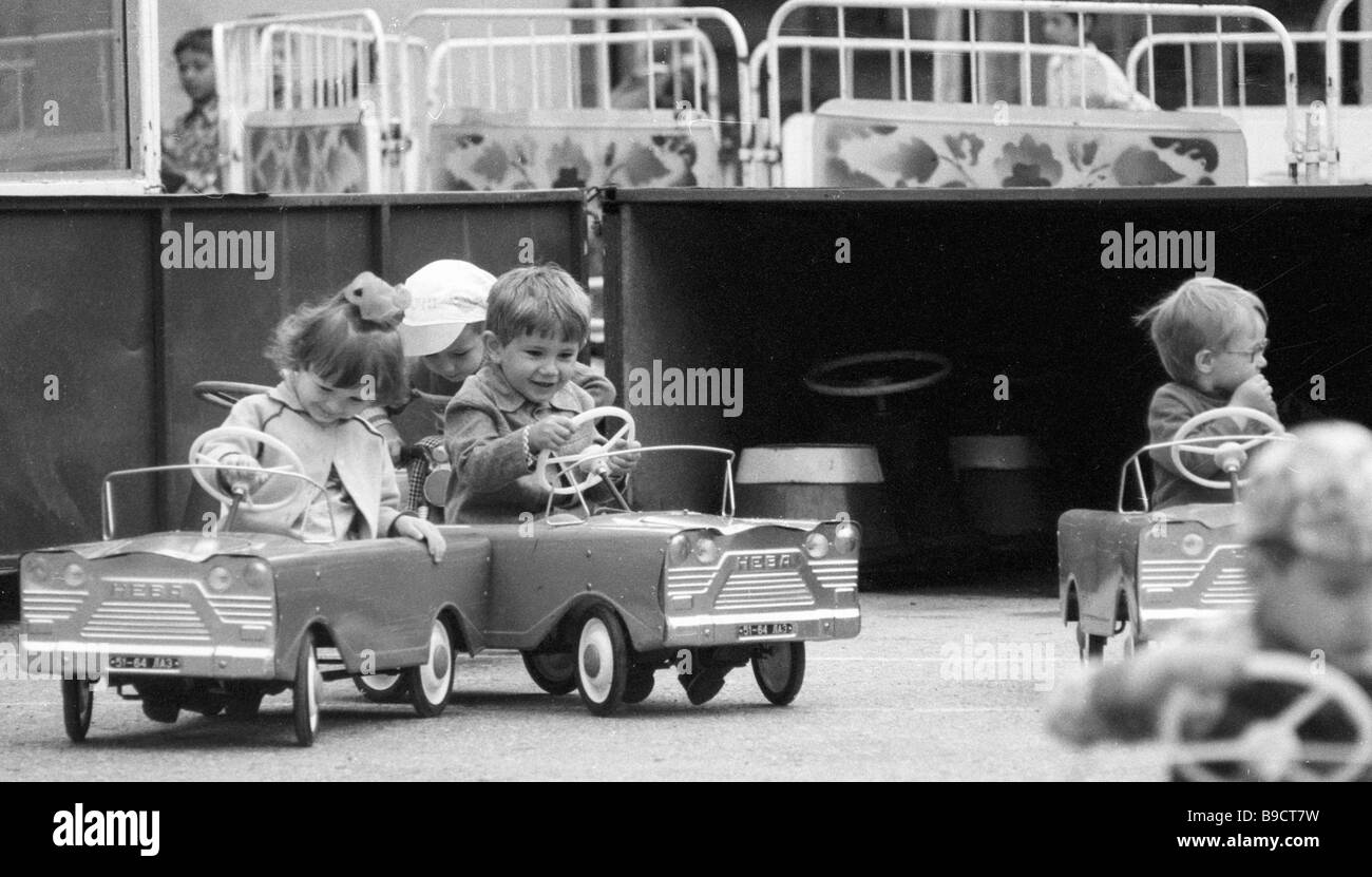 Children drive pedal cars at a park autodrome in Ukhta Stock Photo