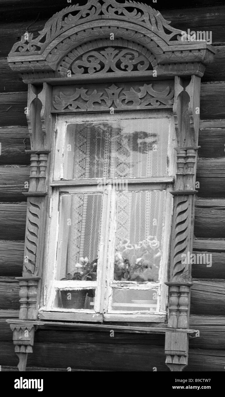A window with carved casing jambs and lintel in a wooden house Stock ...