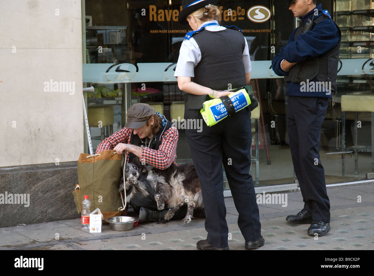 Homeless man and dog being questioned by community police Stock Photo