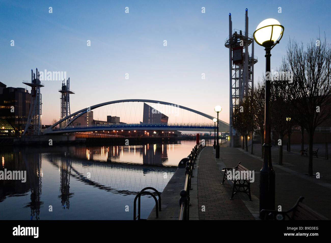 The Millennium footbridge at sunset with the Imperial War Museum North behind, Salford Quays, Greater Manchester, England Stock Photo