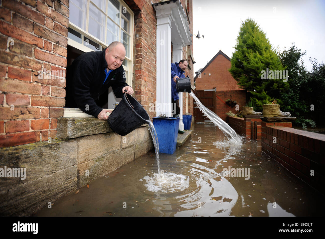 RESIDENTS BAIL FLOODWATER FROM THEIR HOUSE IN STONEHOUSE NEAR STROUD GLOUCESTERSHIRE UK JAN 2008 Stock Photo