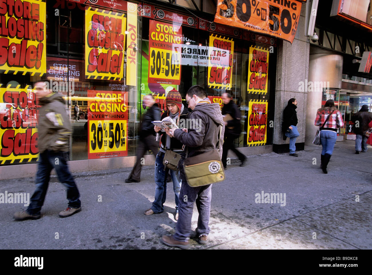 New York going out of business liquidation sale.Tourists looking at a map on the street in front of closing store on Broadway in Midtown Manhattan USA Stock Photo