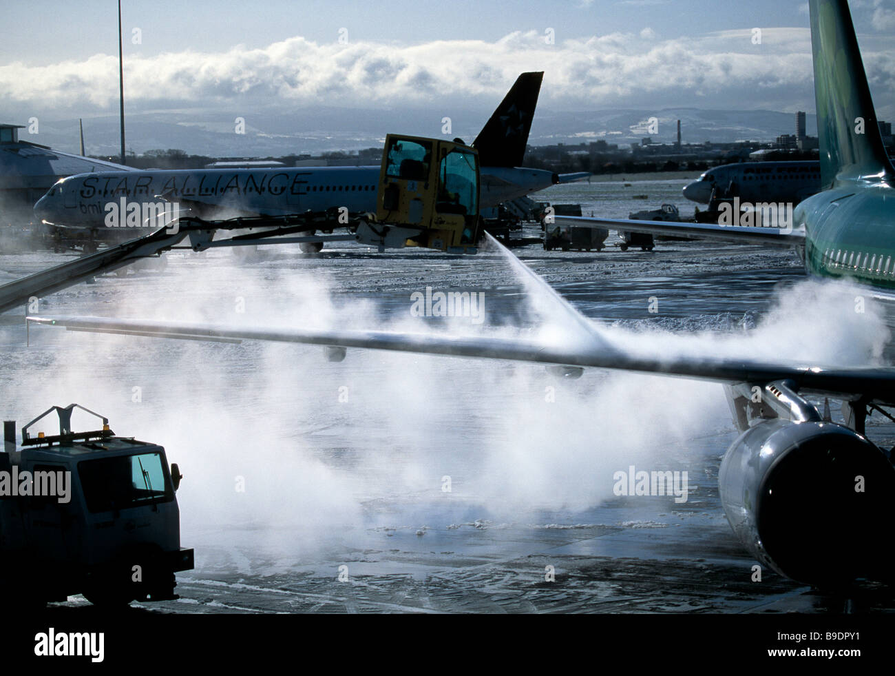 jet airliner wings being sprayed with solution to deice the wings during bad winter weather Stock Photo