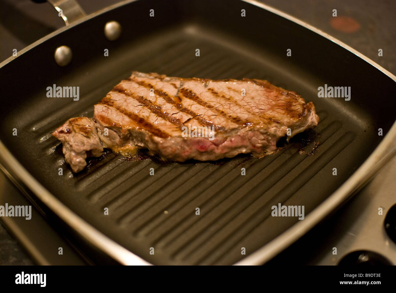 A sirloin steak frying in a griddle pan Stock Photo Alamy