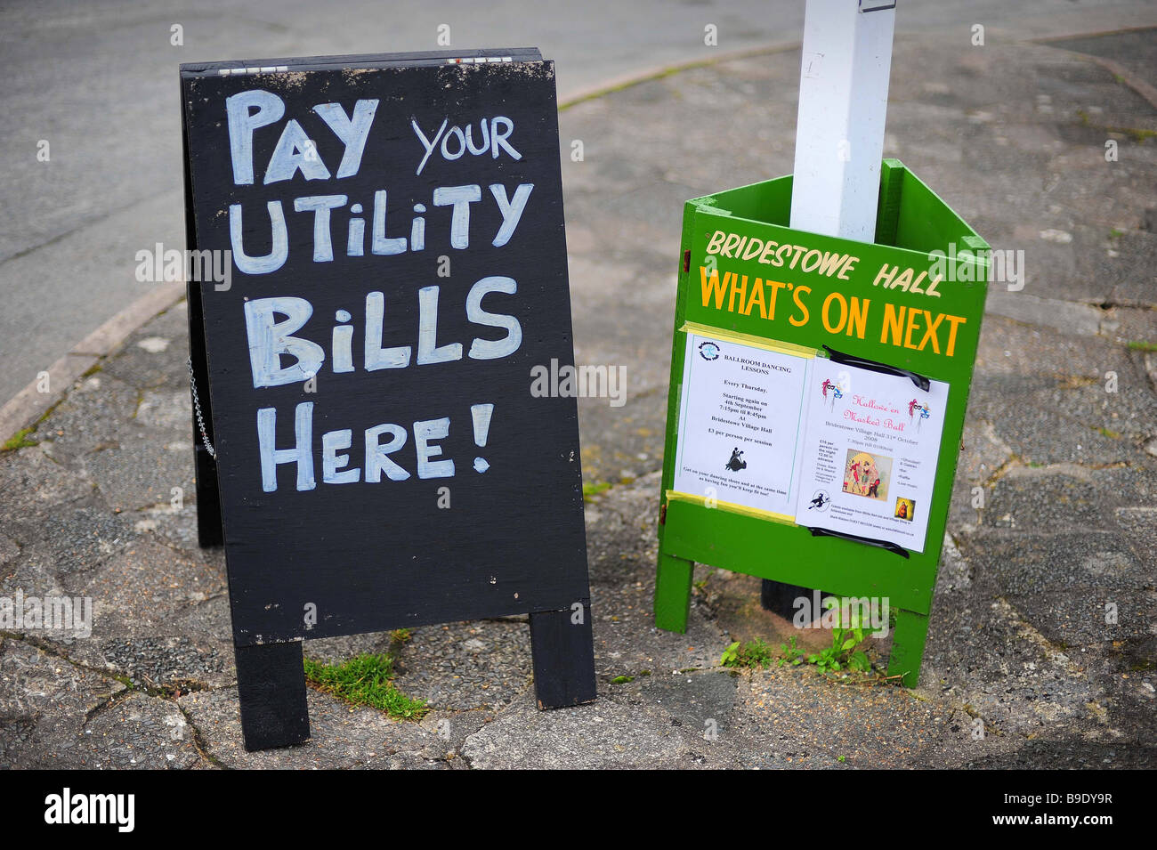 a pay your utility bills sign outside a village post office Stock Photo