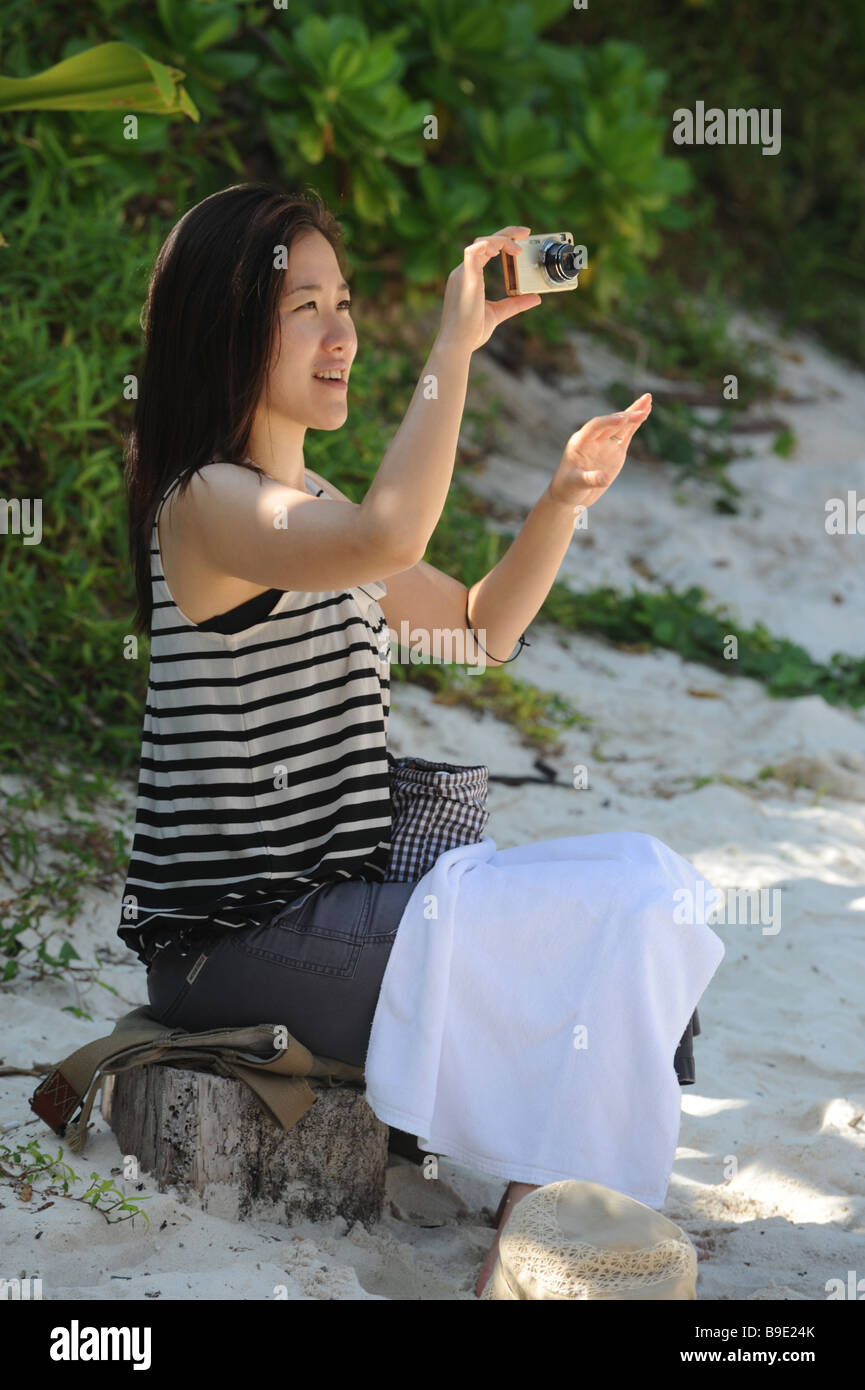 Japanese tourist takilg a photograph on a island  beach off the coast of Phuket Thailand Stock Photo