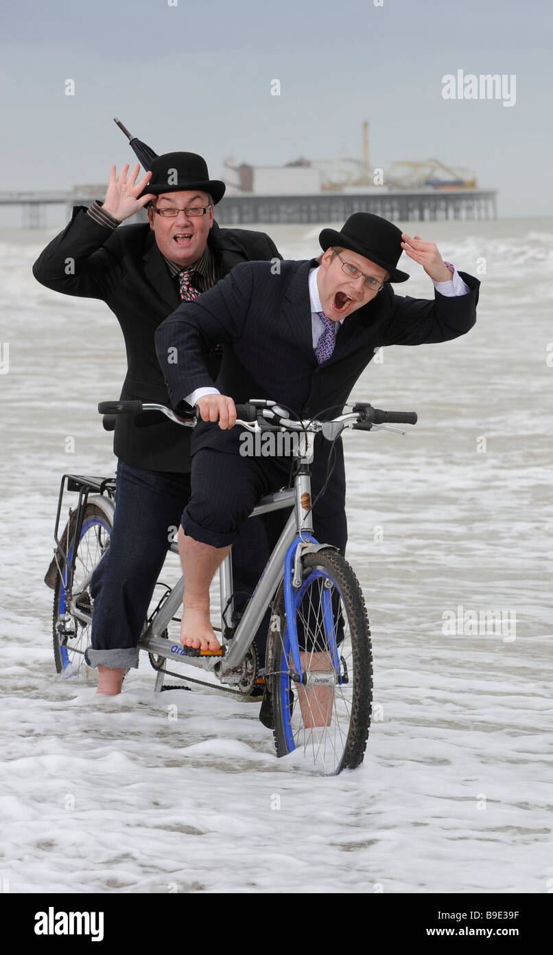 City gents limber up on Brighton beach with their tandem before competing in 'The Rat Race' event . Stock Photo