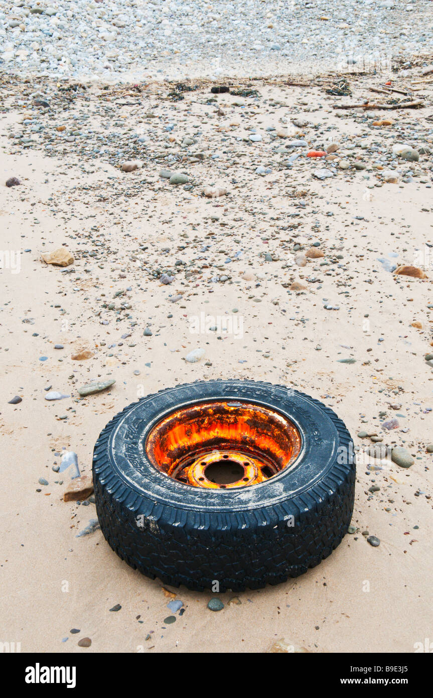 An old truck wheel and tyre washed up on a UK Beach Stock Photo
