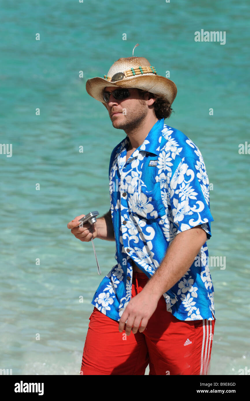 A tourist in a bright Hawaian Shirt and hat on Maya Beach off the coast of Phuket Thailand Stock Photo