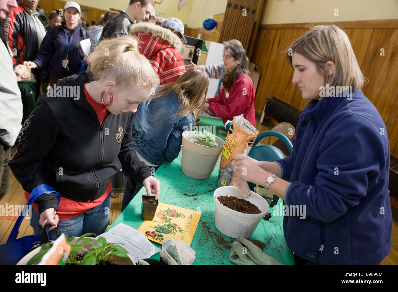 Kids and parents learning about planting seeds at a Green Fair in