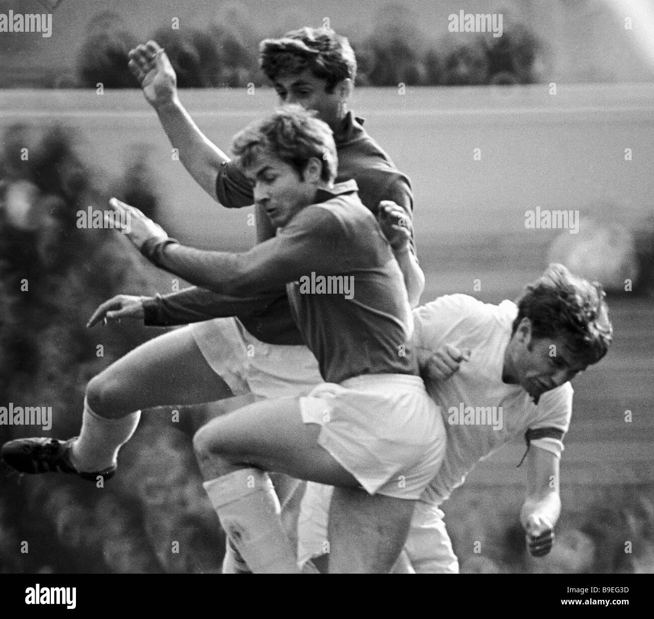 Football players reaching for the ball Stock Photo - Alamy